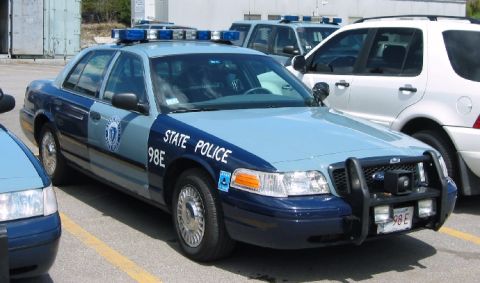 1998 Ford Crown Victoria - Massachusetts State Police car, a 1998 Ford Crown Victoria, parked outdoors with other vehicles.