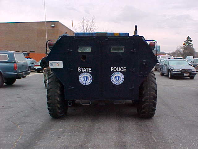 Dark blue State Police armored personnel carrier rear view with Massachusetts seal in parking lot