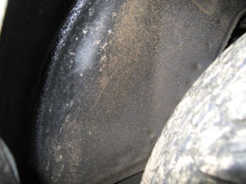 1991 Ford LTD Crown Victoria - A close-up view of a vehicle's dusty wheel well, showing the tire and inner fender.