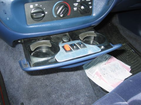 1996 Ford Crown Victoria - The open compartment in the car's dashboard contains papers and other items.