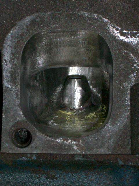 1973 Ford Ranchero - Close-up view of an engine cylinder head port, showing the conical valve guide within the opening.