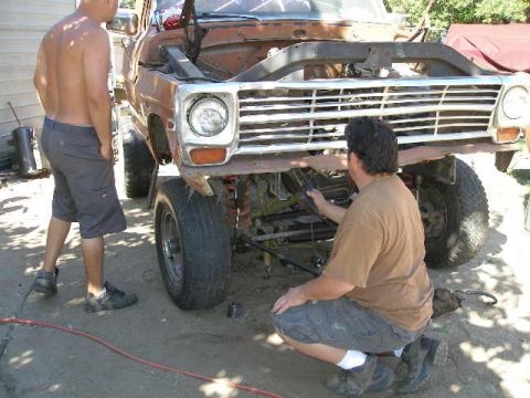 1969 Ford F-250 - Mechanics work on the front end of a 1969 Ford F-250 truck.