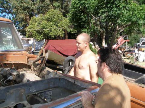 1969 Ford F-250 - Two men are working on a vintage truck that appears to be undergoing some form of restoration or repair.