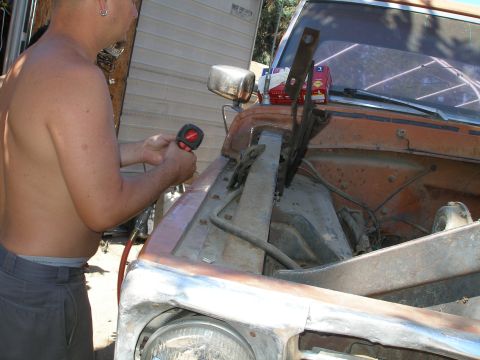 1969 Ford F-250 - A man works on the engine of an orange 1967 Ford F-100 truck.