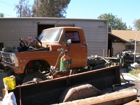1969 Ford F-250 - This truck appears to be undergoing some form of repair or modification, with its engine exposed and welding equipment nearby.