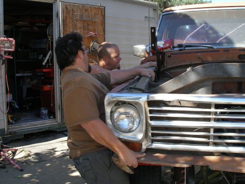 1969 Ford F-250 - Men work on the front end of a truck, with a tool trailer behind them.