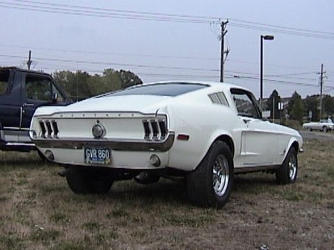 1968 Ford Mustang - The rear view of a white fastback coupe shows its distinctive taillights and a license plate.