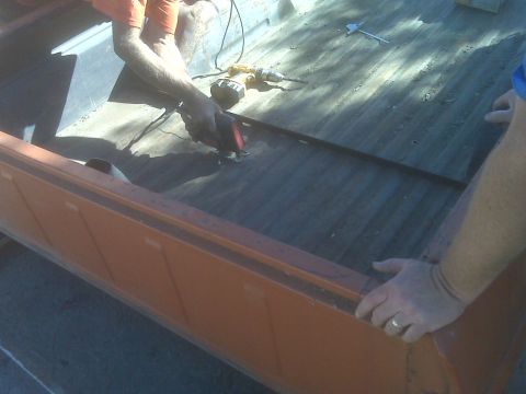 1969 Ford F-250 - Work is being done on the bed of a truck, with tools and hands visible.