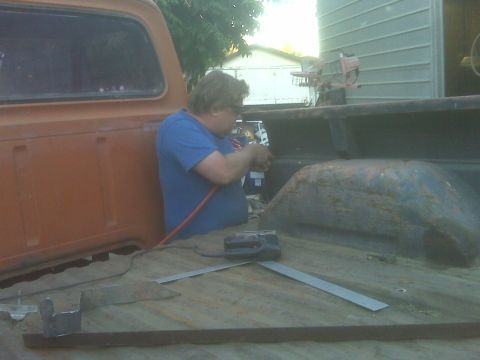 1969 Ford F-250 - A person is working on the truck bed with a jigsaw and other tools.