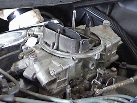 1968 Ford Mustang - A detailed view of a vehicle's carburetor, showing its intricate mechanical parts.