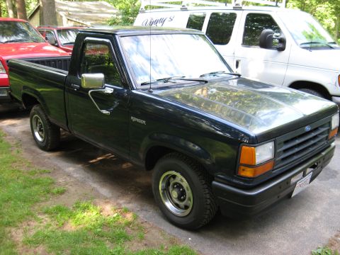 1989 Ford Ranger - This black 1989 Ford Ranger pickup truck is parked next to other vehicles.