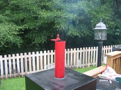 1992 Ford Bronco - A red smoker pipe is emitting smoke in a backyard setting with a white picket fence and a lamppost.