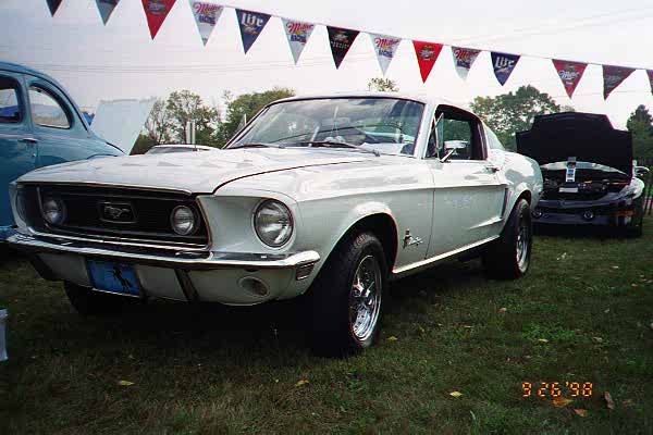 White 1968 Ford Mustang front 3/4 view with a blue license plate
