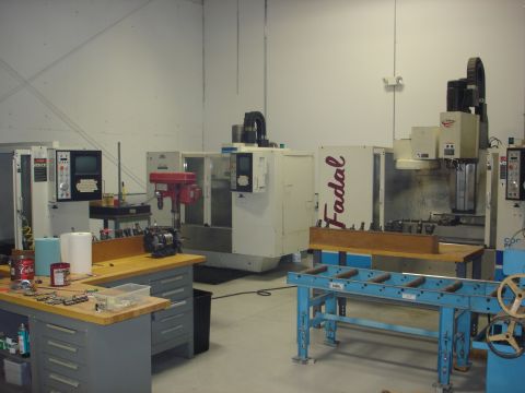 1979 Ford F-250 - A view inside a machine shop CNC equipment and a workbench with tools and supplies.