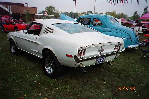 White Ford Mustang fastback rear 3/4 view at outdoor car show