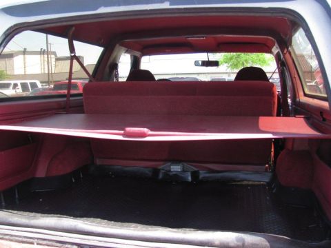 1995 Ford Bronco - The spacious interior of a 1995 Ford Bronco, showing the cargo area with seats folded down and a removable cover.