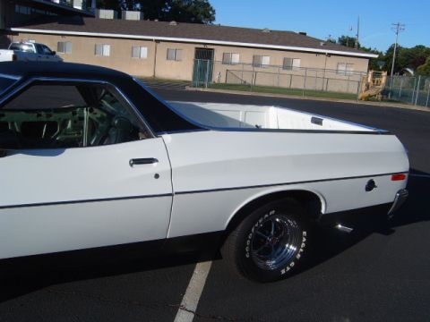 1973 Ford Ranchero - Side profile of a white 1973 Ford Ranchero pickup truck with a black vinyl roof.