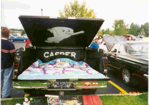 1994 Ford F-150 - A black pickup truck bed features a Casper the Friendly Ghost mural and a colorful blanket, with a license plate visible.