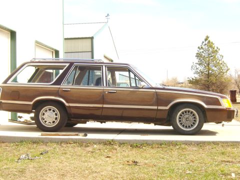1984 Ford LTD - Station wagon with wood paneling parked outside a building.
