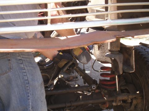 1969 Ford F-250 - Mechanic working on the front suspension and grille of a 1969 Ford F-250.