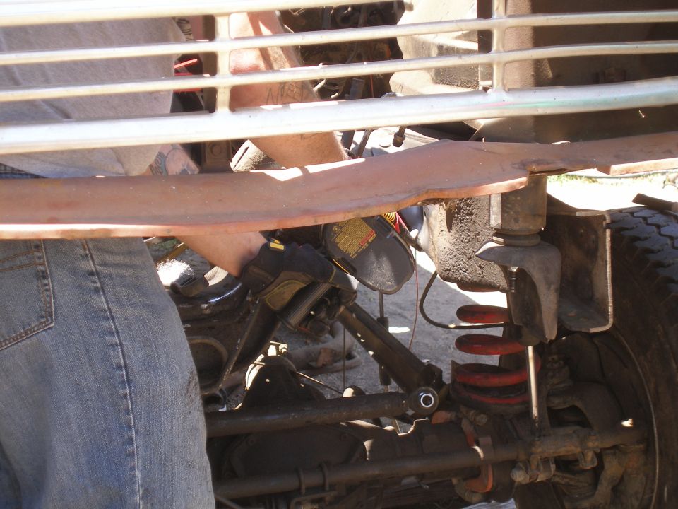 1969 Ford F-250 front suspension and grille with a person working on it
