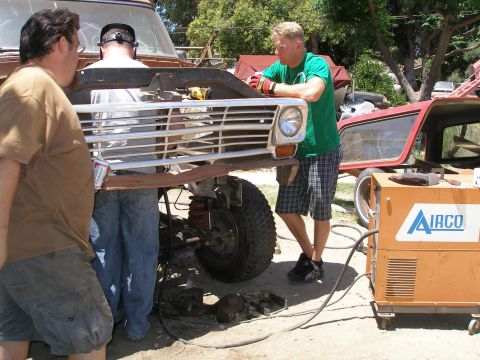 1969 Ford F-250 - Men are working on the front end of a truck, possibly a 1967 Ford F-Series, with a welder ready.