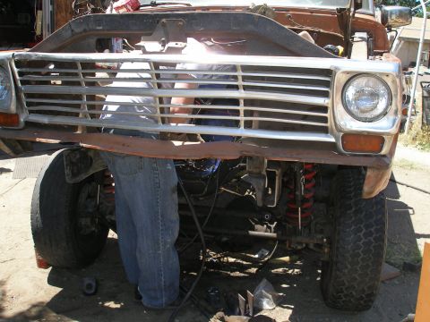 1969 Ford F-250 - Mechanic works on the front end of a Ford truck, showing the grille and suspension components.