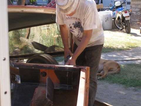 1969 Ford F-250 - A person is using a grinder on the metal frame of what appears to be a vehicle.