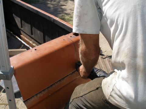 1969 Ford F-250 - A person is working on the bed of an orange pickup truck, with a Supermotors logo visible at the bottom right.