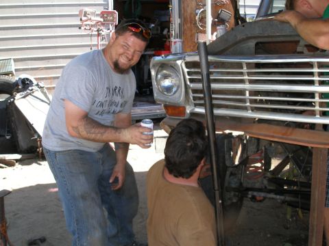 1969 Ford F-250 - Two men work on the front end of a Ford F-Series truck, identified by its grille as a 1973 model.