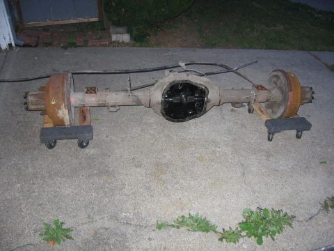 1989 Ford Bronco - A disassembled rear axle assembly rests on a concrete surface, awaiting repair or replacement.
