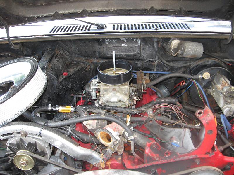 Engine bay with carburetor and air filter. SuperMotors.net logo visible