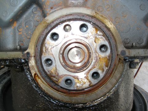 1969 Ford F-250 - Engine crankshaft seal area showing wear and oil. No year is visible.