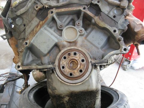 1969 Ford F-250 - Close-up of an engine block's rear seal and oil pan, showing wear and grime.