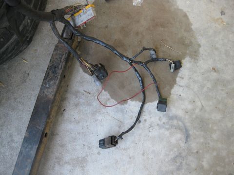 1969 Ford F-250 - Engine wiring harness with various connectors and a yellow fuse box is laid out on a concrete surface.