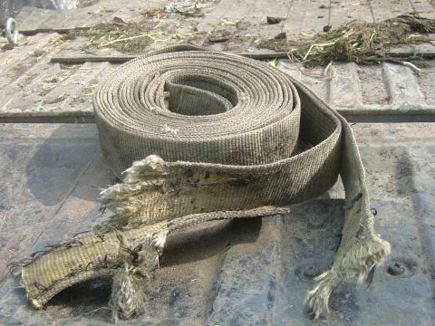 1978 Chevrolet C/K Pickup - A frayed tie-down strap is coiled in the bed of a truck, showing signs of wear and tear.