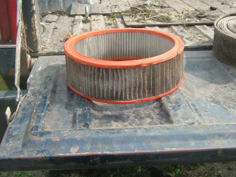 1978 Chevrolet C/K Pickup - A used air filter rests on the dusty bed of a pickup truck.
