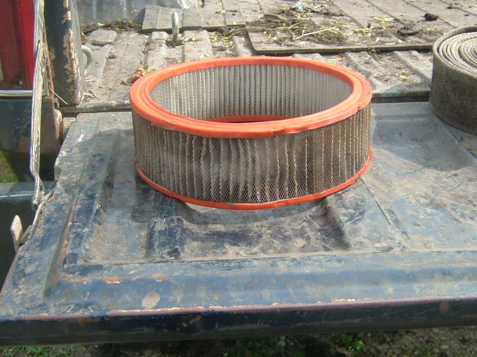 Dirty air filter with orange rim on the bed of a truck