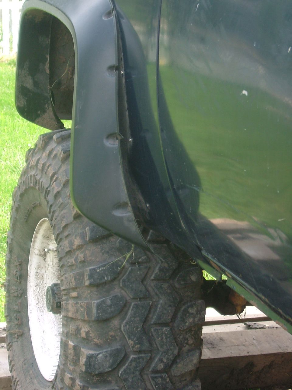Dark green pickup truck fender flare and large tire