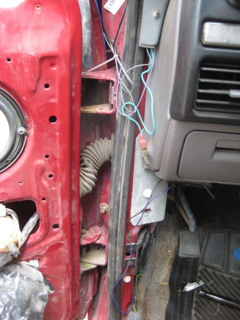 1995 Ford Bronco - Exposed wiring and door hinge area in a vehicle's interior.
