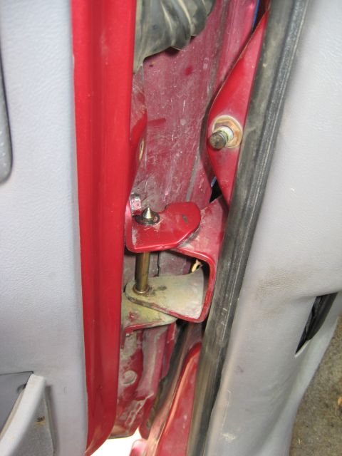 1995 Ford Bronco - Detail of a vehicle's door hinge assembly, showing the pivot and mounting points.