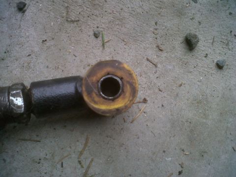 1978 Ford Bronco - A close-up view of a vehicle suspension component, a yellow bushing.