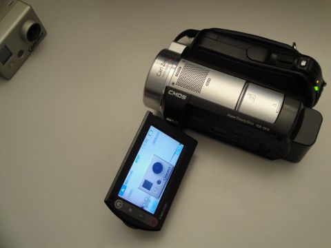 1993 Ford Taurus - A Sony HDR-SR10 Handycam camcorder is shown with its screen open, alongside a GoPro Hero camera.
