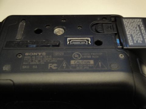1993 Ford Taurus - Close-up of the bottom of a Sony HDR-SR10 digital video camera, revealing various ports and manufacturer information.