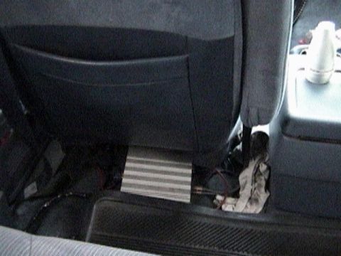 1995 Ford Bronco - The photo shows the interior of a vehicle, focusing on an amplifier installed under the seat.