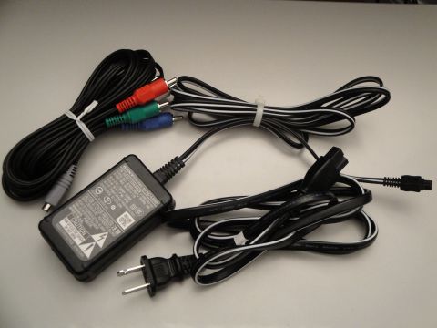 1993 Ford Taurus - A Sony AC adapter and a set of red, green, and blue RCA cables are laid out on a white surface.