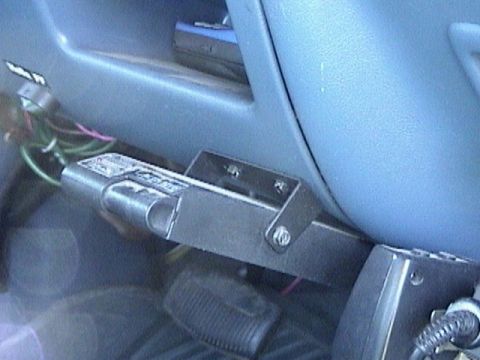 1995 Ford Bronco - Under-dash interior detail shot showing a black accessory box or control unit mounted to a fabricated steel bracket bolted beneath the blue…