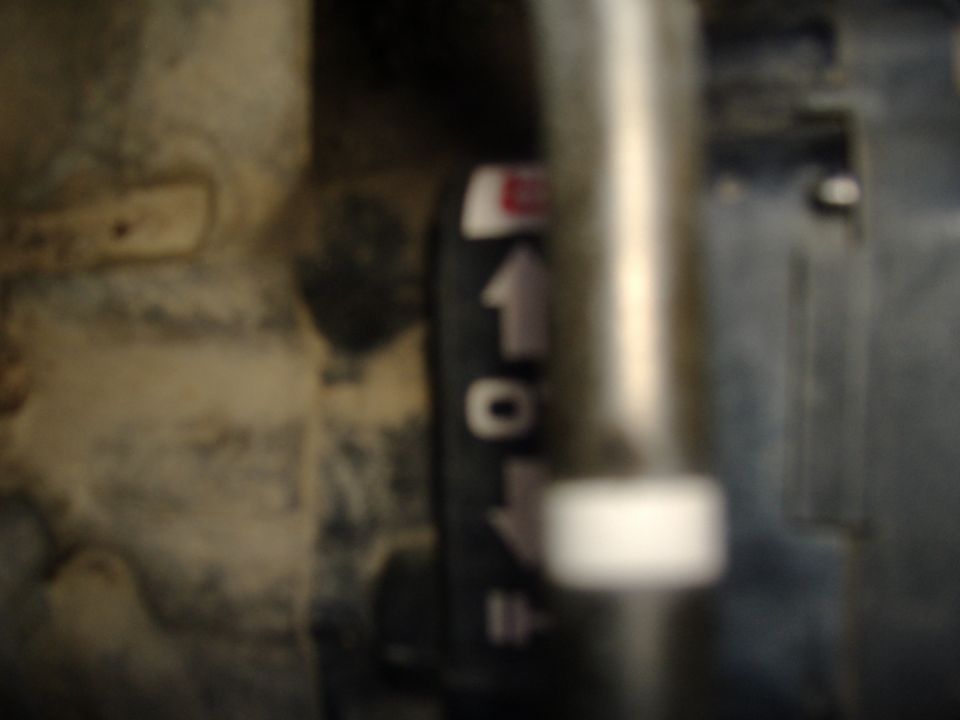 Blurry close-up of a transmission shifter scale marking 1-0-2