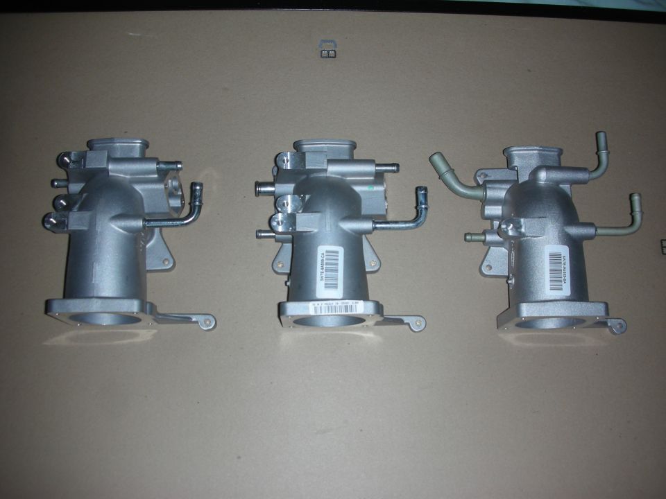Three silver intake manifolds with hoses and labels