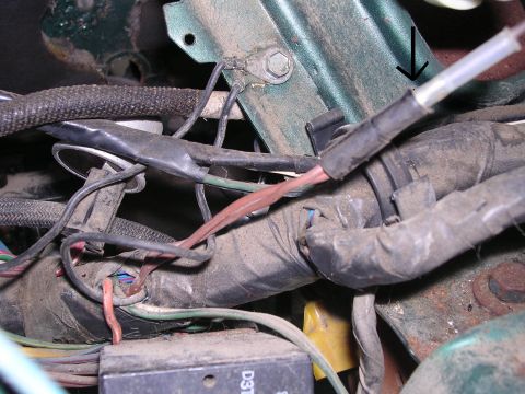 1978 Ford Bronco - Close-up view of a vehicle's engine wiring harness, showing various wires and a green bracket.